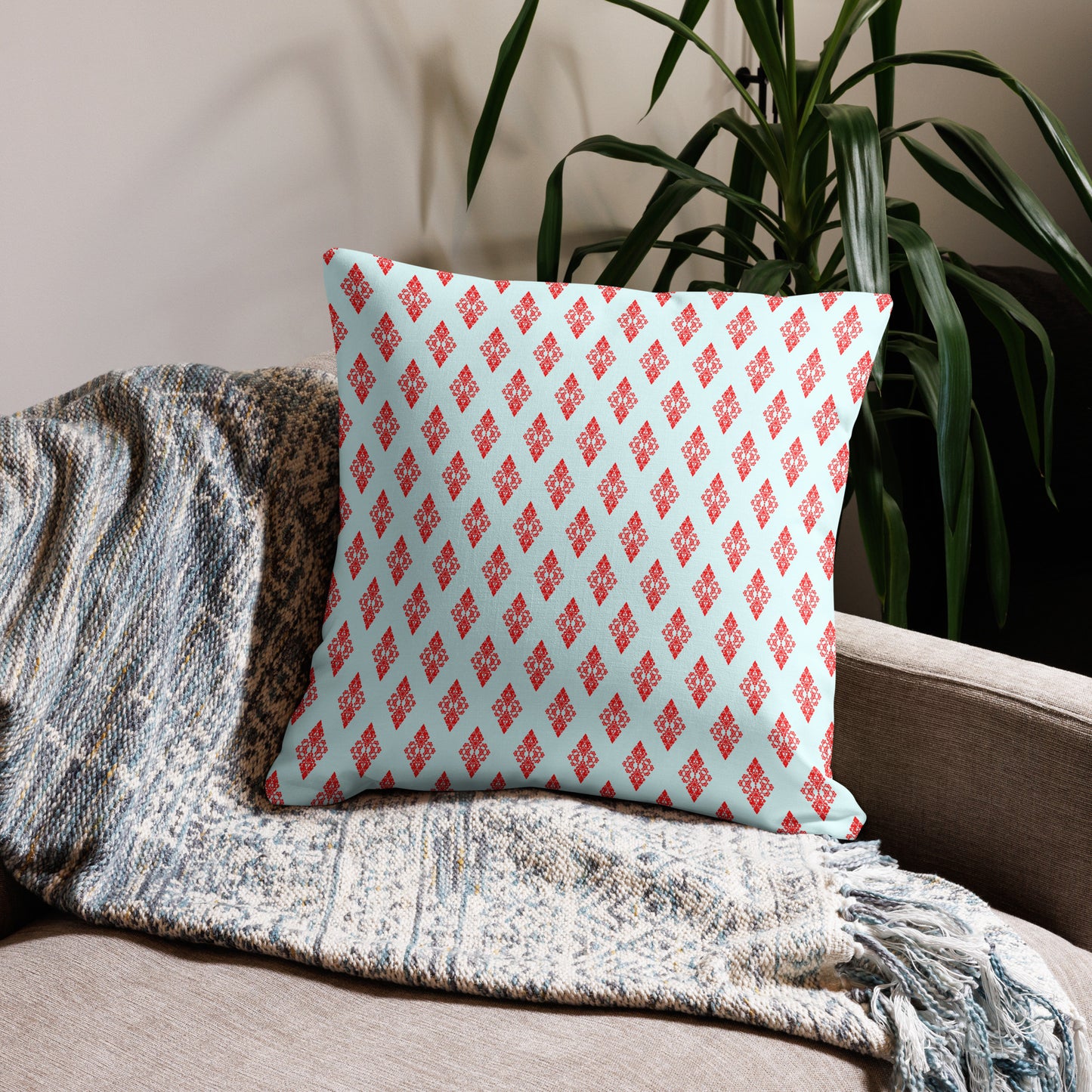 22″×22″ premium throw pillow with the 'Digon' sky blue and red geometric pattern on a couch.