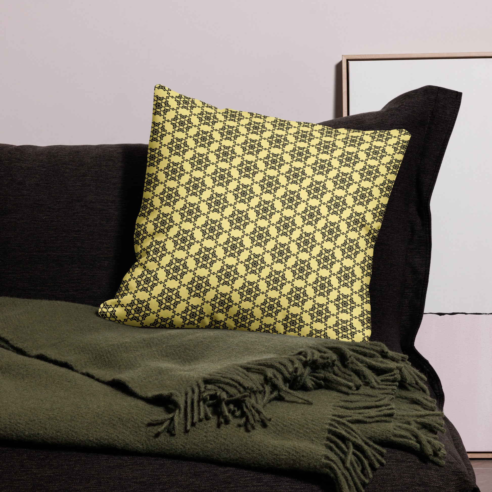 22″×22″ premium throw pillow with the 'Hexagon' yellow and black geometric pattern on a couch.