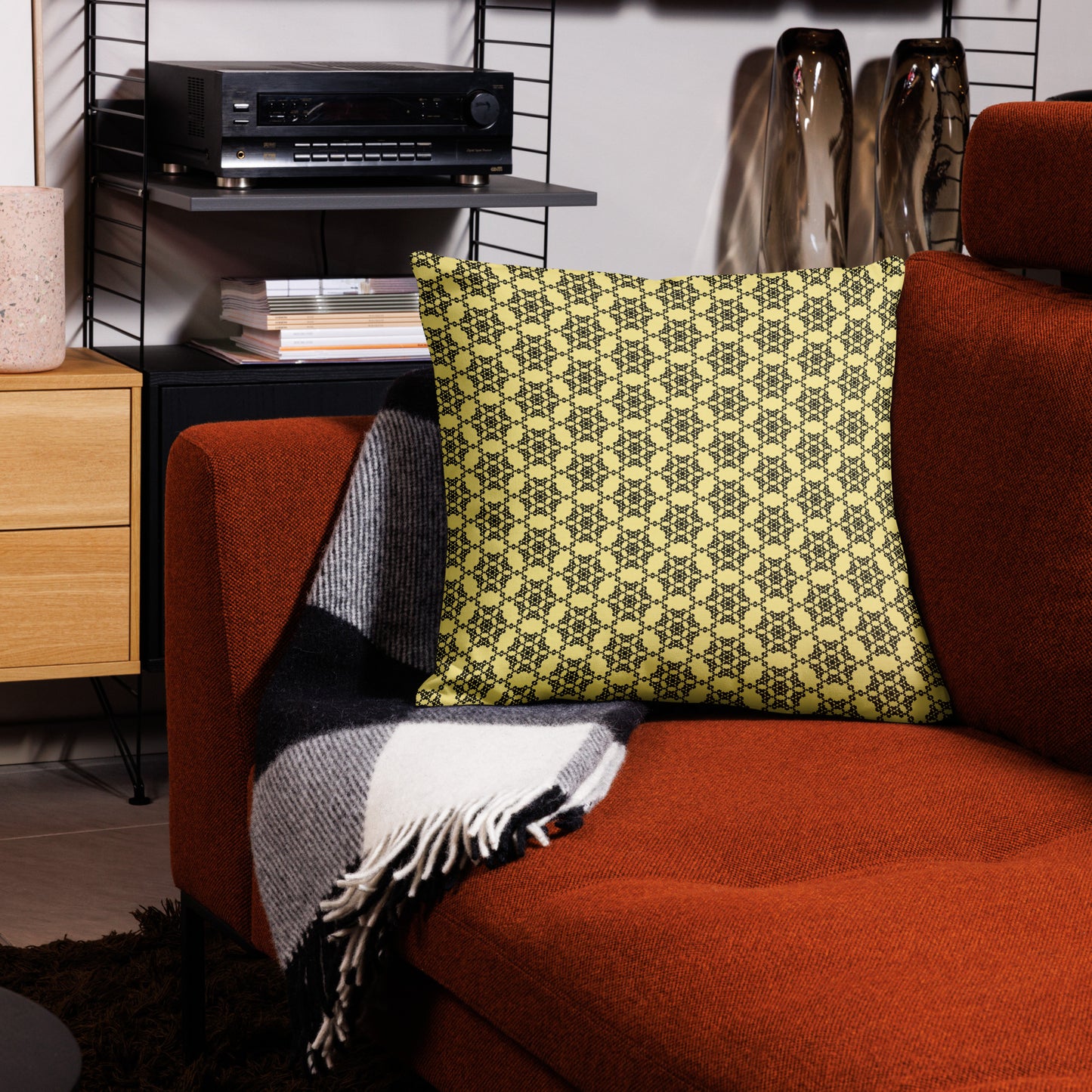 22″×22″ premium throw pillow with the 'Hexagon' yellow and black geometric pattern on a couch.