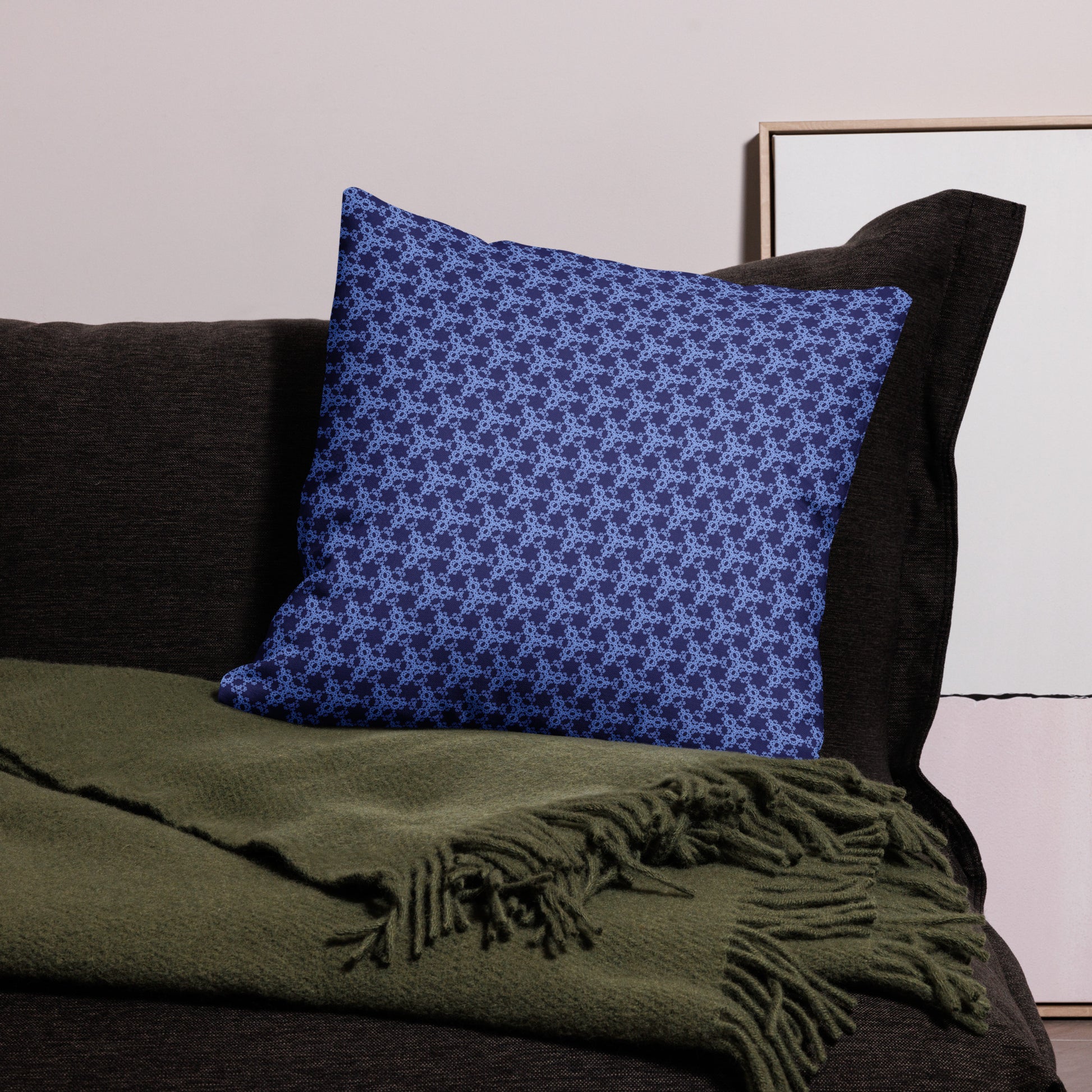 22″×22″ premium throw pillow with the 'Trigon' navy and blue geometric pattern on a couch.