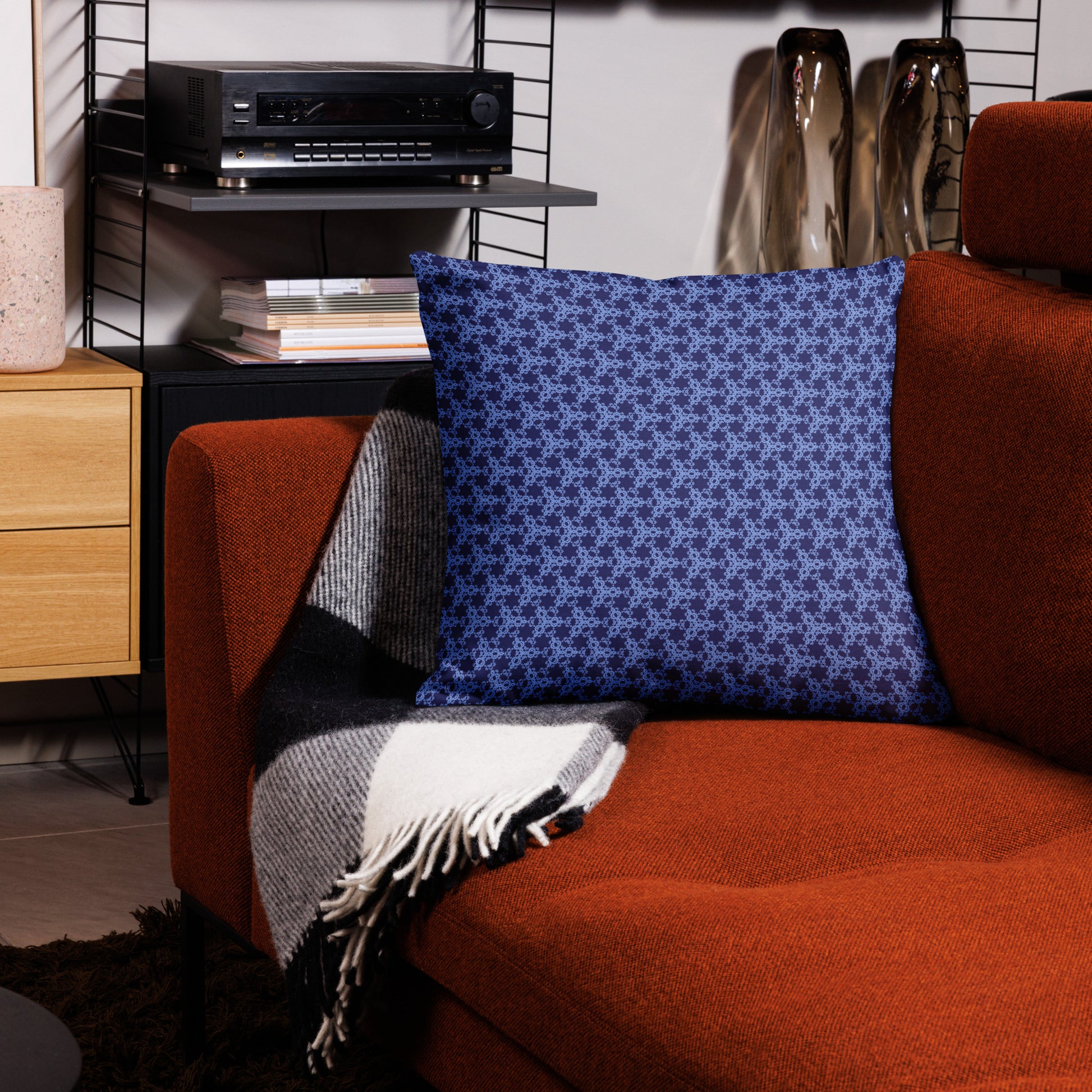 22″×22″ premium throw pillow with the 'Trigon' navy and blue geometric pattern on a couch.