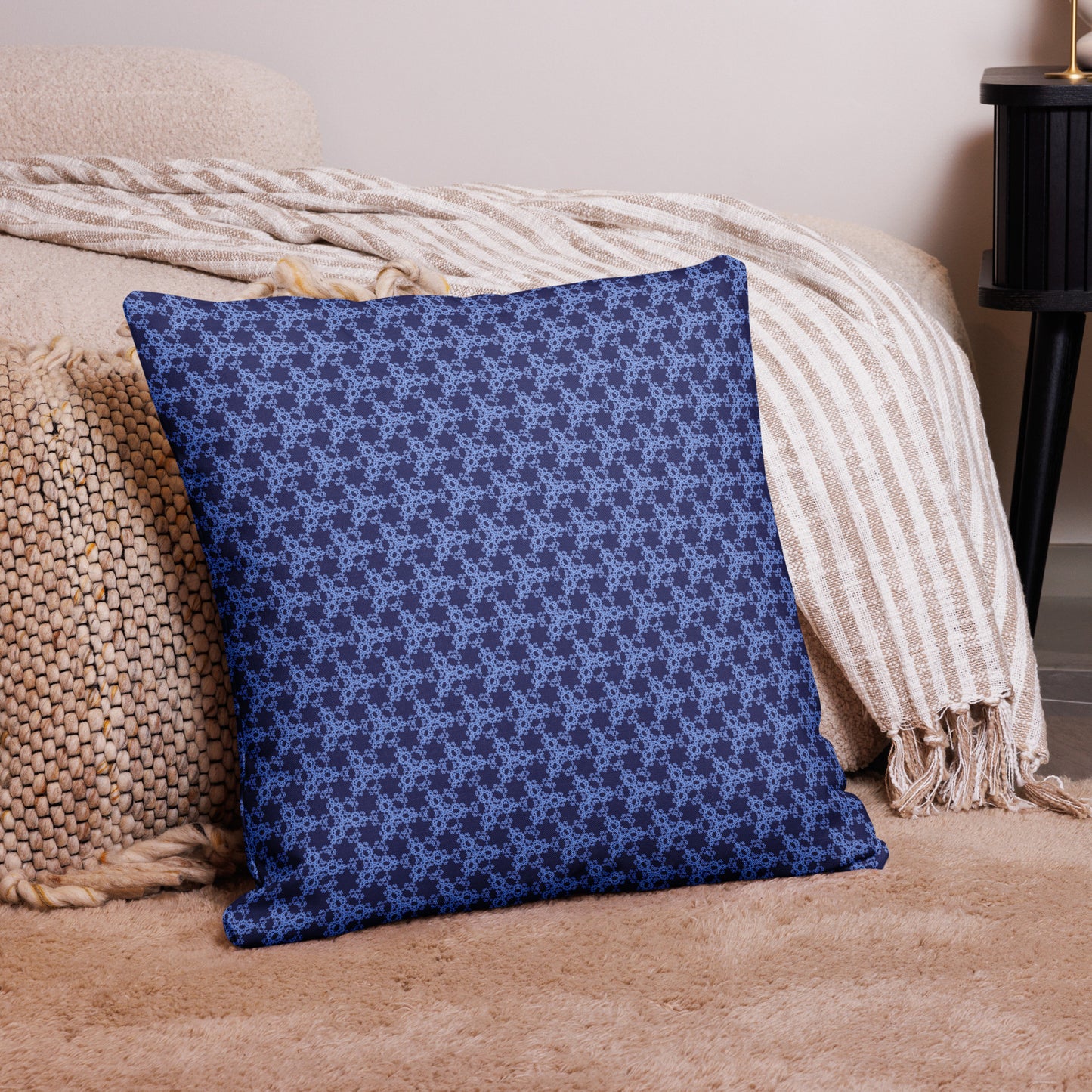 22″×22″ premium throw pillow with the 'Trigon' navy and blue geometric pattern on a couch.