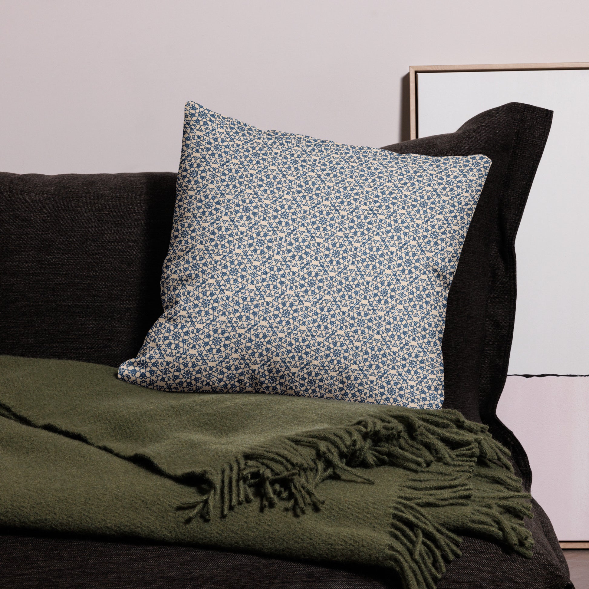 22″×22″ premium throw pillow with the ‘Octagon’ navy and beige geometric pattern on a dark sofa with throw blanket.