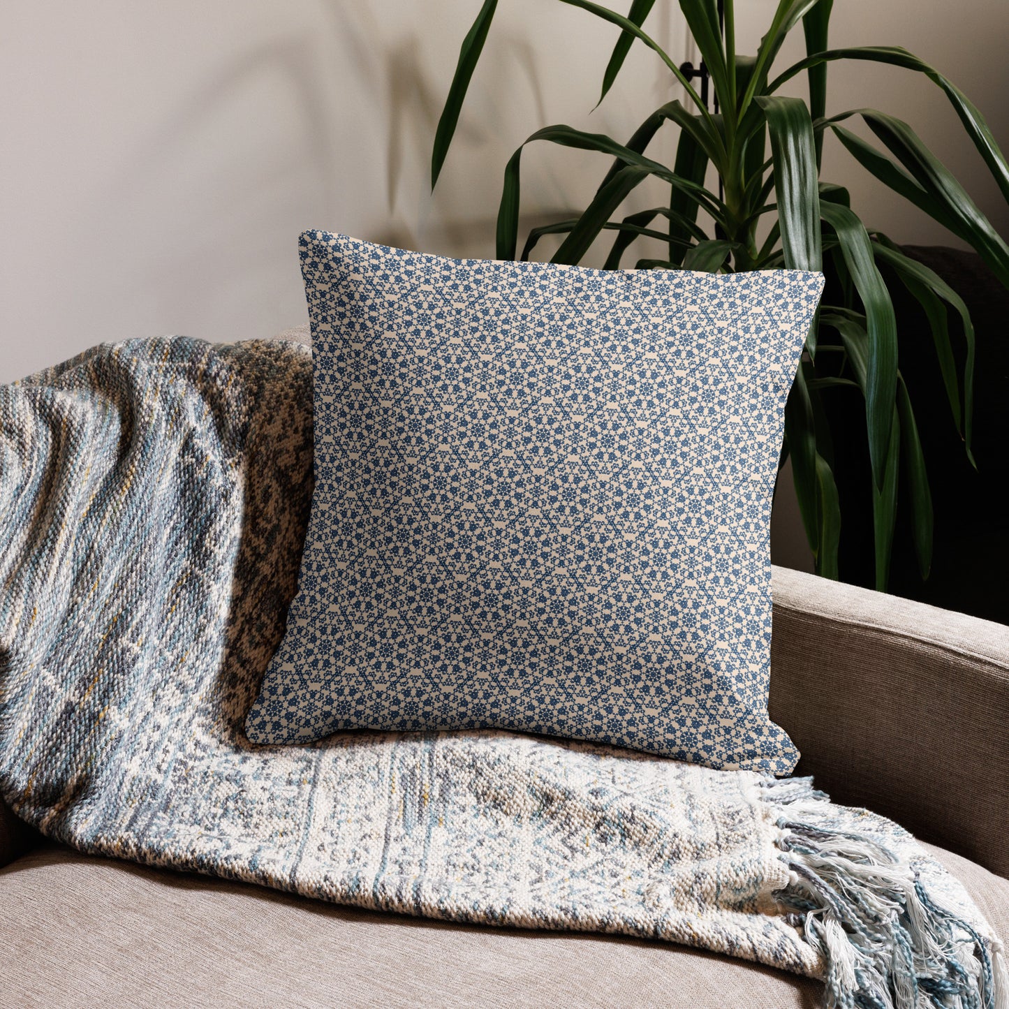 22″×22″ premium throw pillow with the ‘Octagon’ navy and beige geometric pattern on a sofa with fringed blanket.