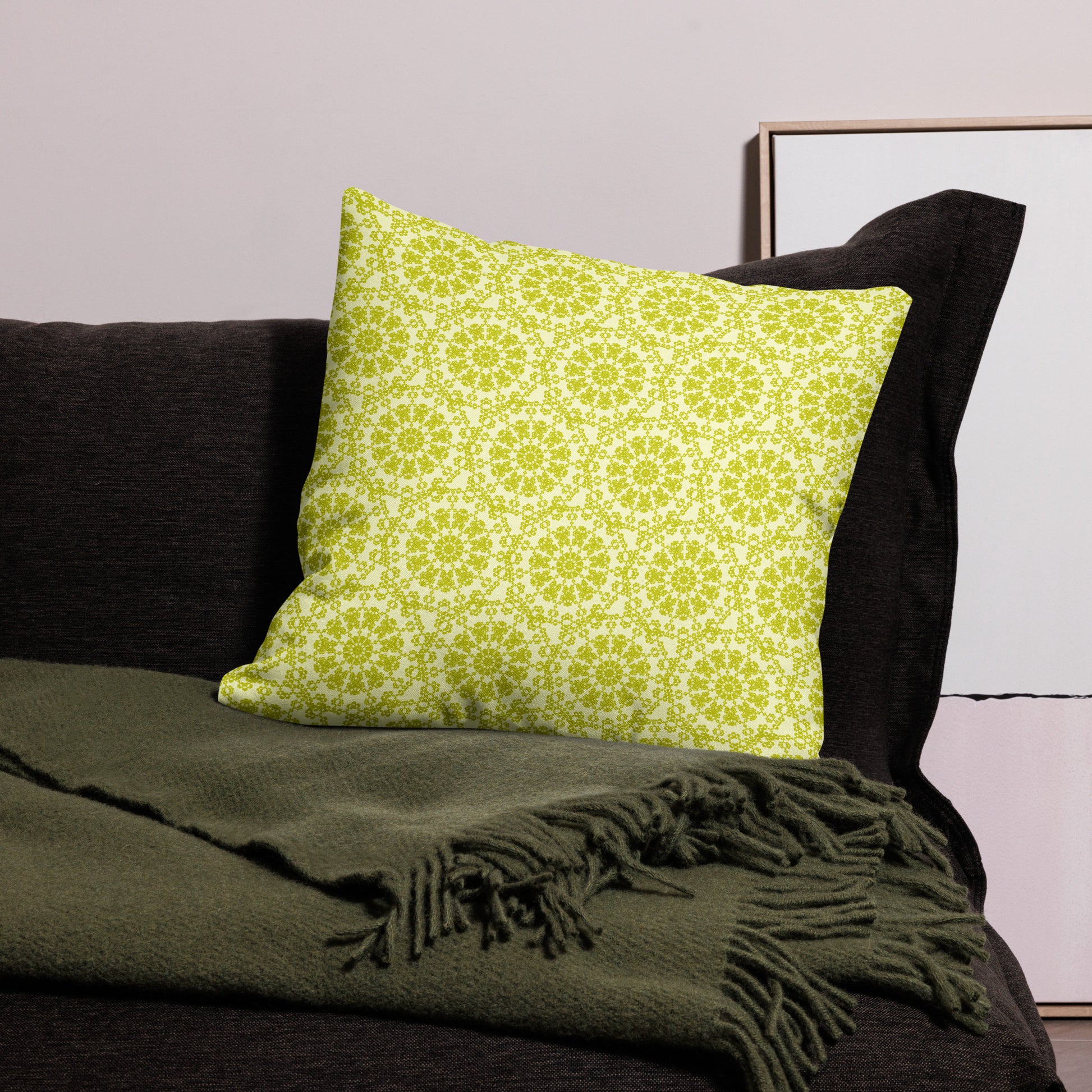 22″×22″ premium throw pillow with the 'Hendecagon' yellow-green geometric pattern on a dark sofa with green throw