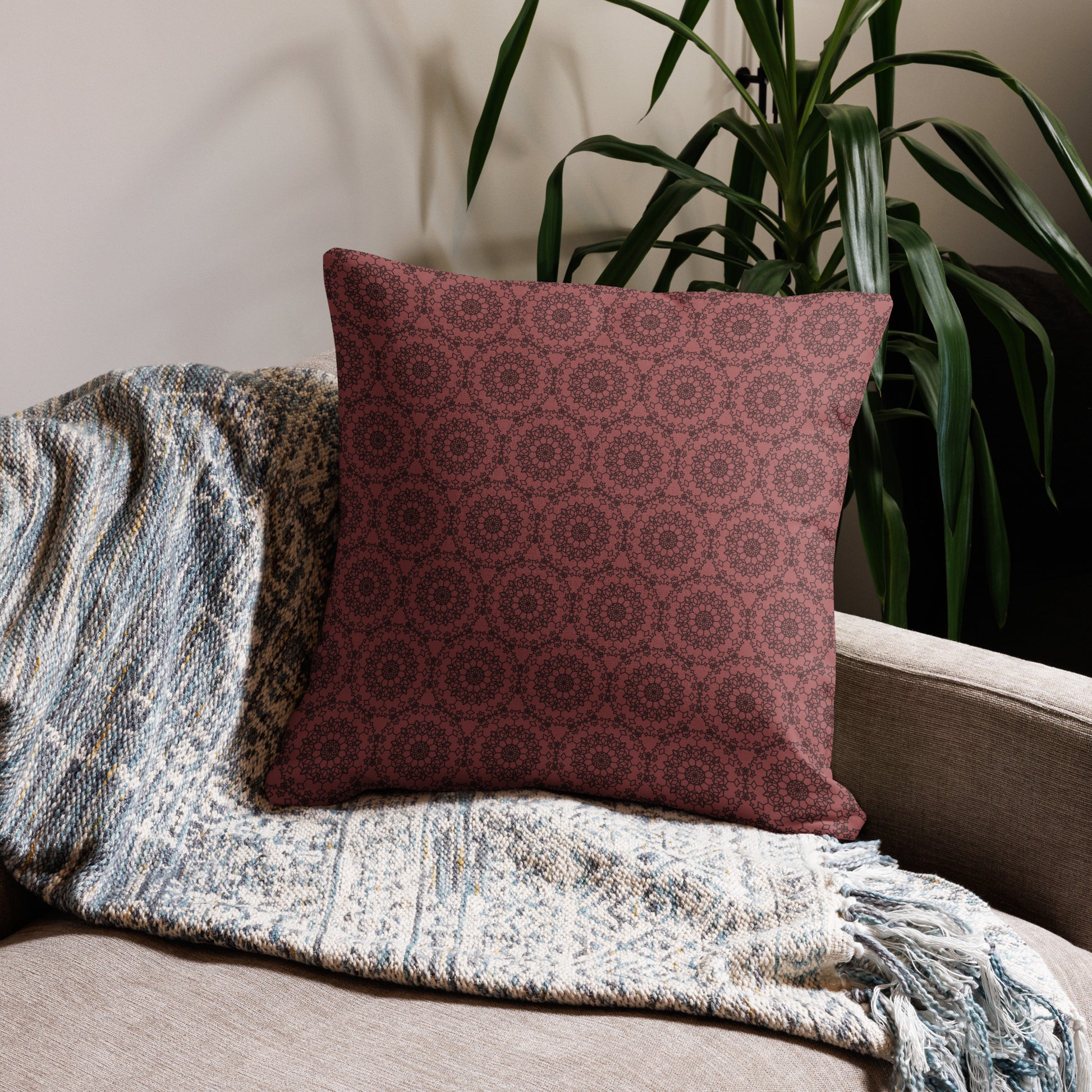 22″×22″ premium throw pillow with the 'Dodecagon' rose geometric pattern on beige sofa with woven throw blanket.