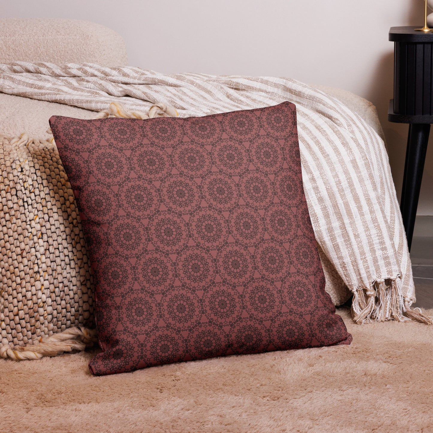 22″×22″ premium throw pillow with the 'Dodecagon' rose geometric pattern on carpet beside bed with striped throw.