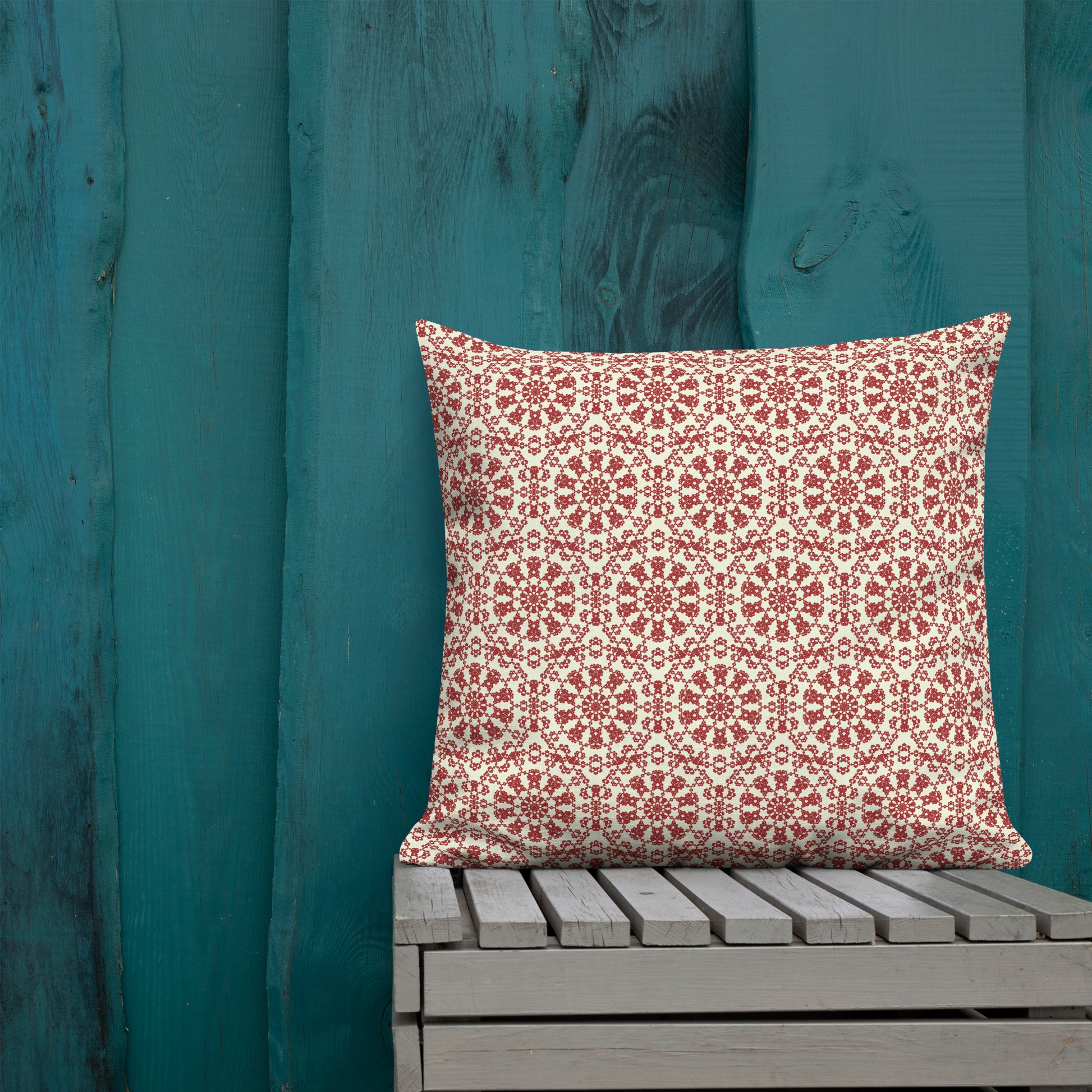 22″×22″ premium throw pillow with the ‘Decagon’ terracotta and beige geometric pattern on an outdoor bench with a teal wooden backdrop.