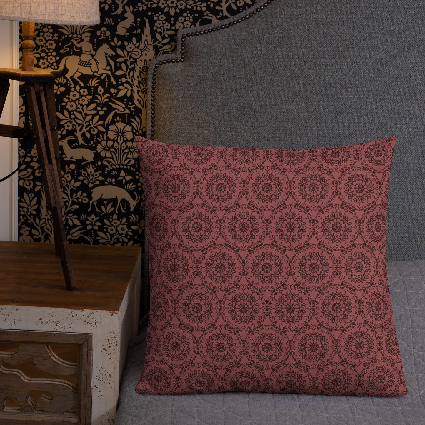 22″×22″ premium throw pillow with the 'Dodecagon' rose geometric pattern on bed beside grey upholstered headboard with lamp.