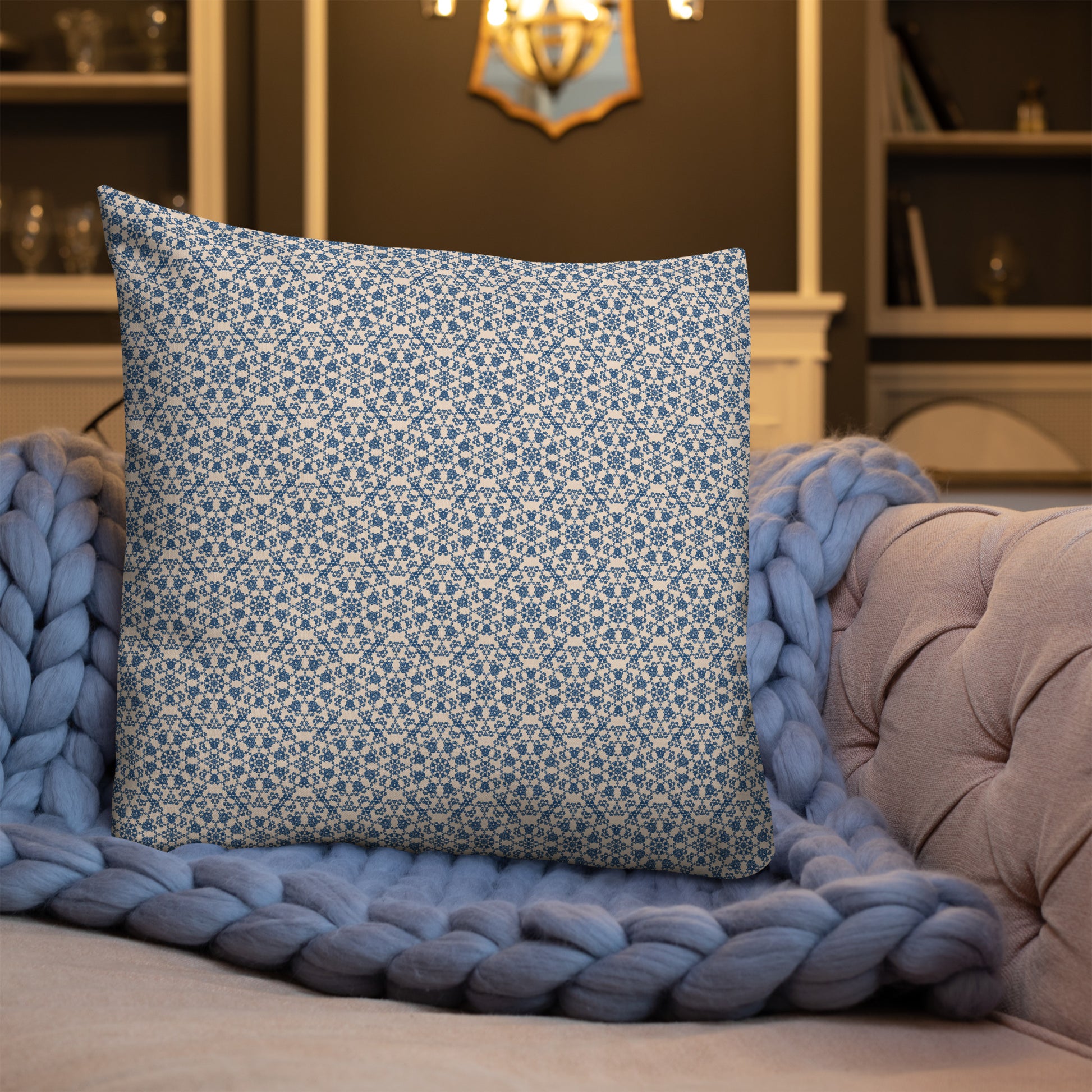 22″×22″ premium throw pillow with the ‘Octagon’ navy and beige geometric pattern on a sofa with chunky knit blanket.