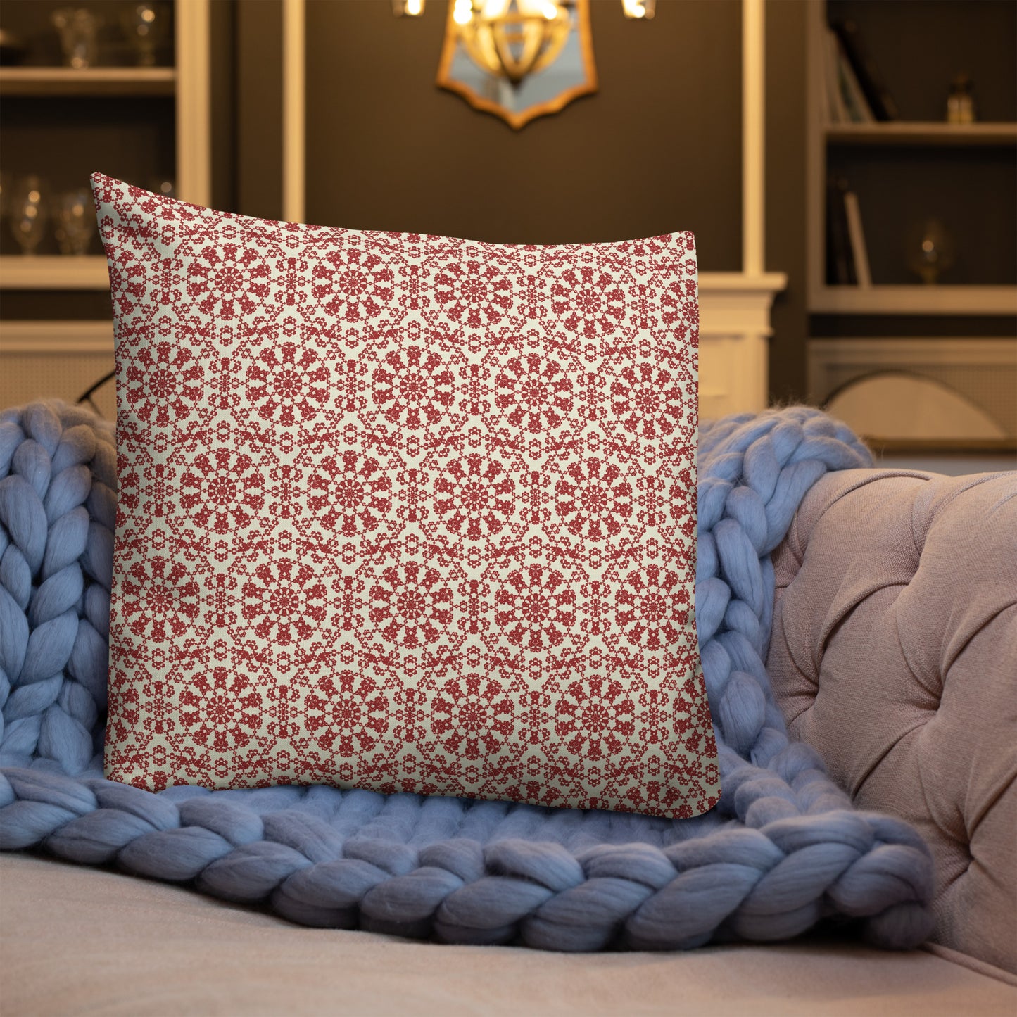 22″×22″ premium throw pillow with the ‘Decagon’ terracotta and beige geometric pattern on a blue sofa with a chunky knit blanket.