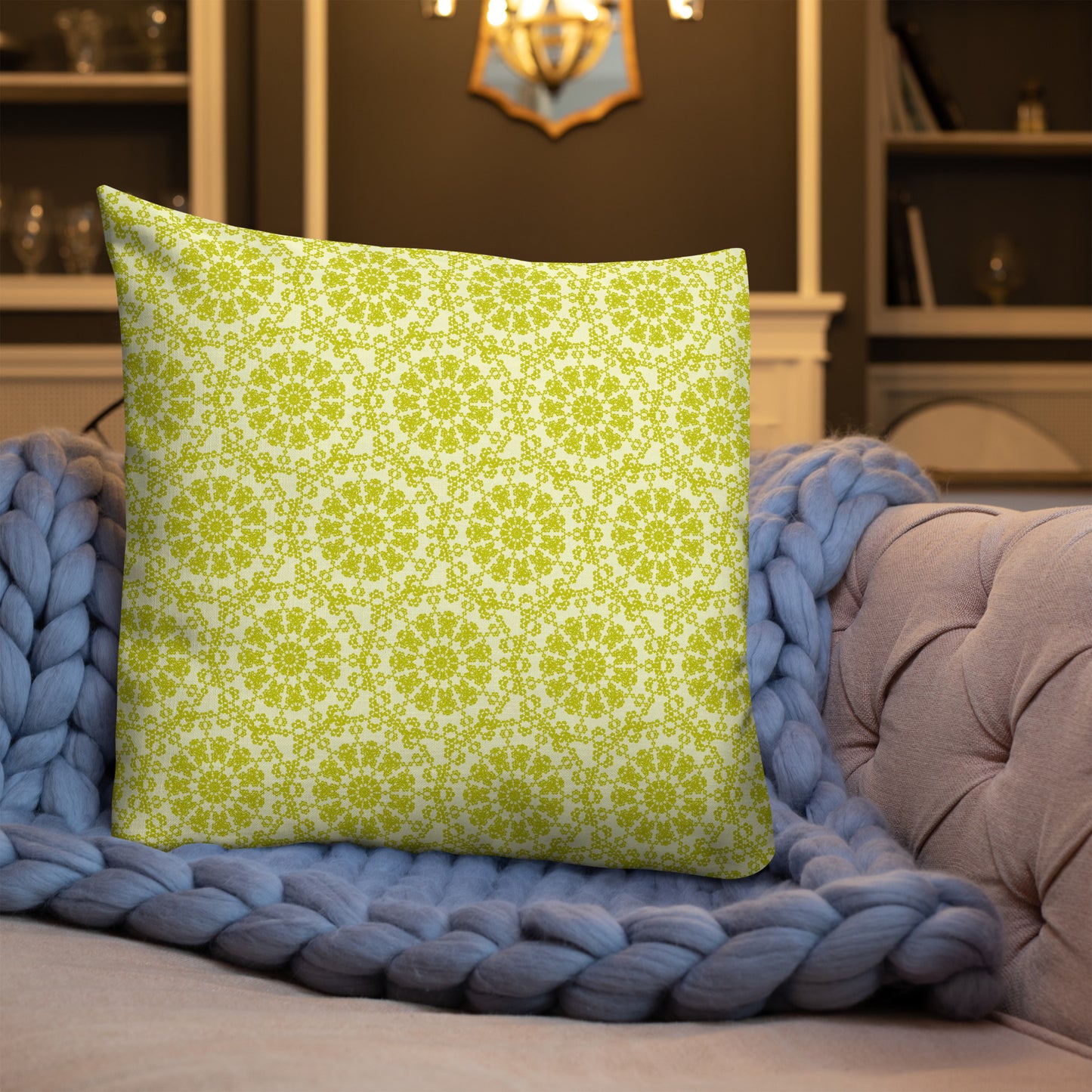 22″×22″ premium throw pillow with the 'Hendecagon' yellow-green geometric pattern on a sofa with chunky knit blanket
