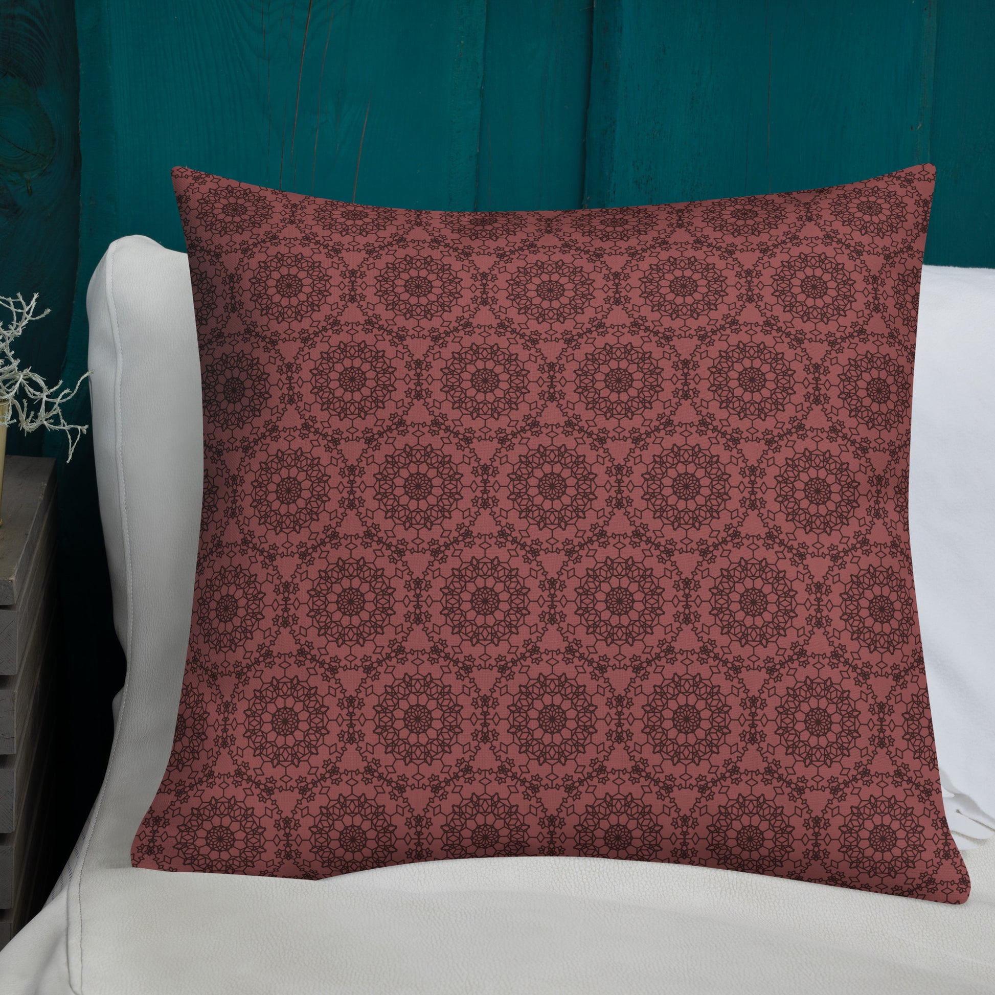 22″×22″ premium throw pillow with the 'Dodecagon' rose geometric pattern on white sofa with teal wooden wall.
