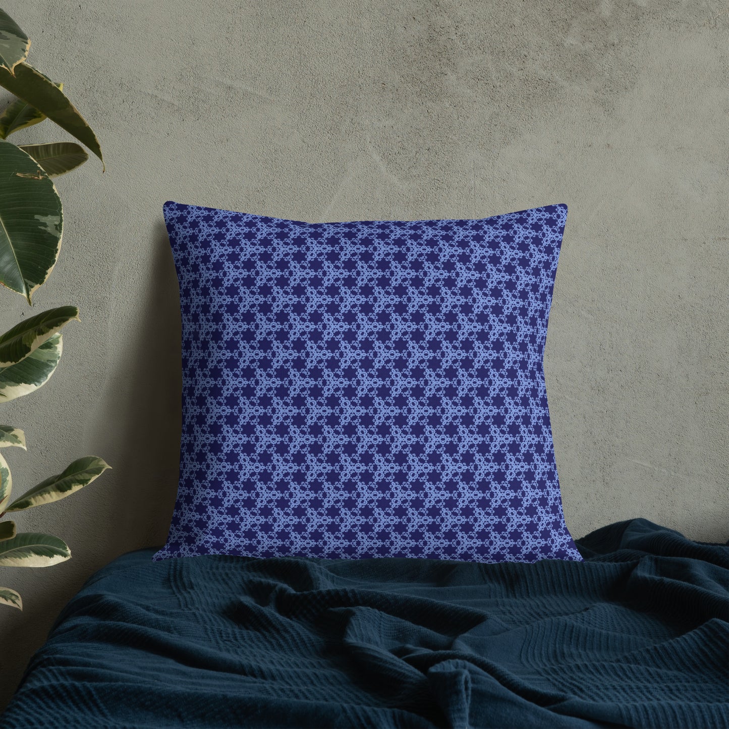 22″×22″ premium throw pillow with the 'Triagon' navy and blue geometric pattern on a bed.