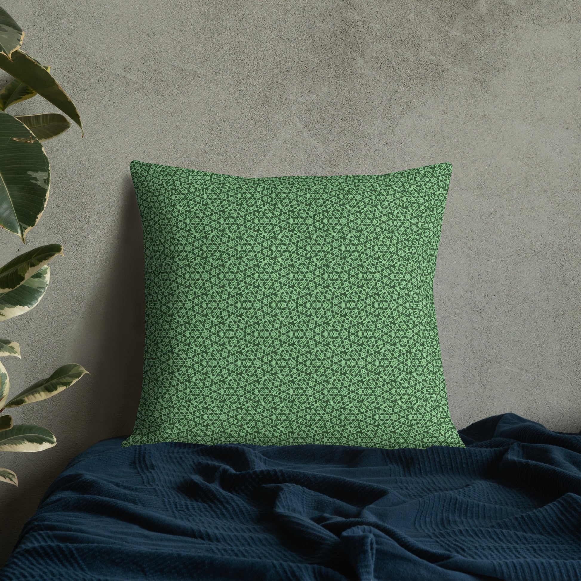 22″×22″ premium throw pillow with the 'Heptagon' green geometric pattern on a bed.