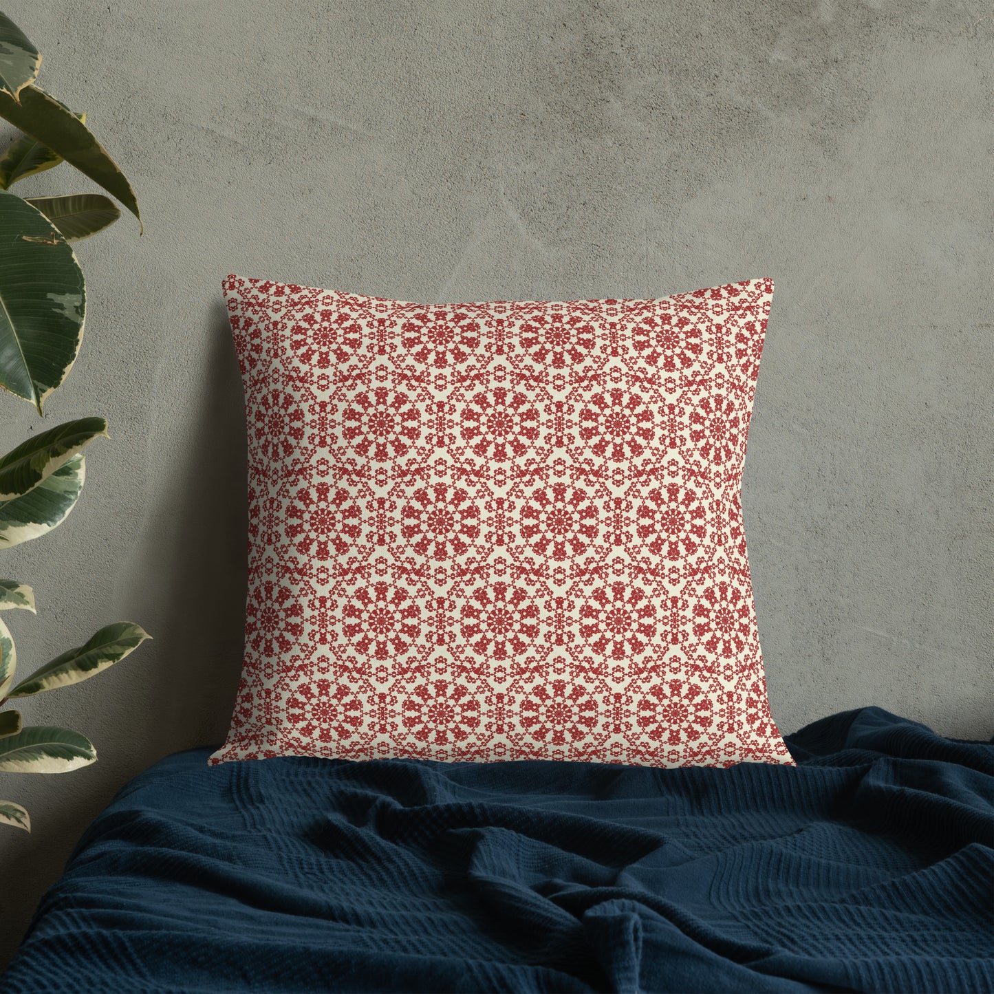 22″×22″ premium throw pillow with the ‘Decagon’ terracotta and beige geometric pattern on a bed with a dark navy blanket.