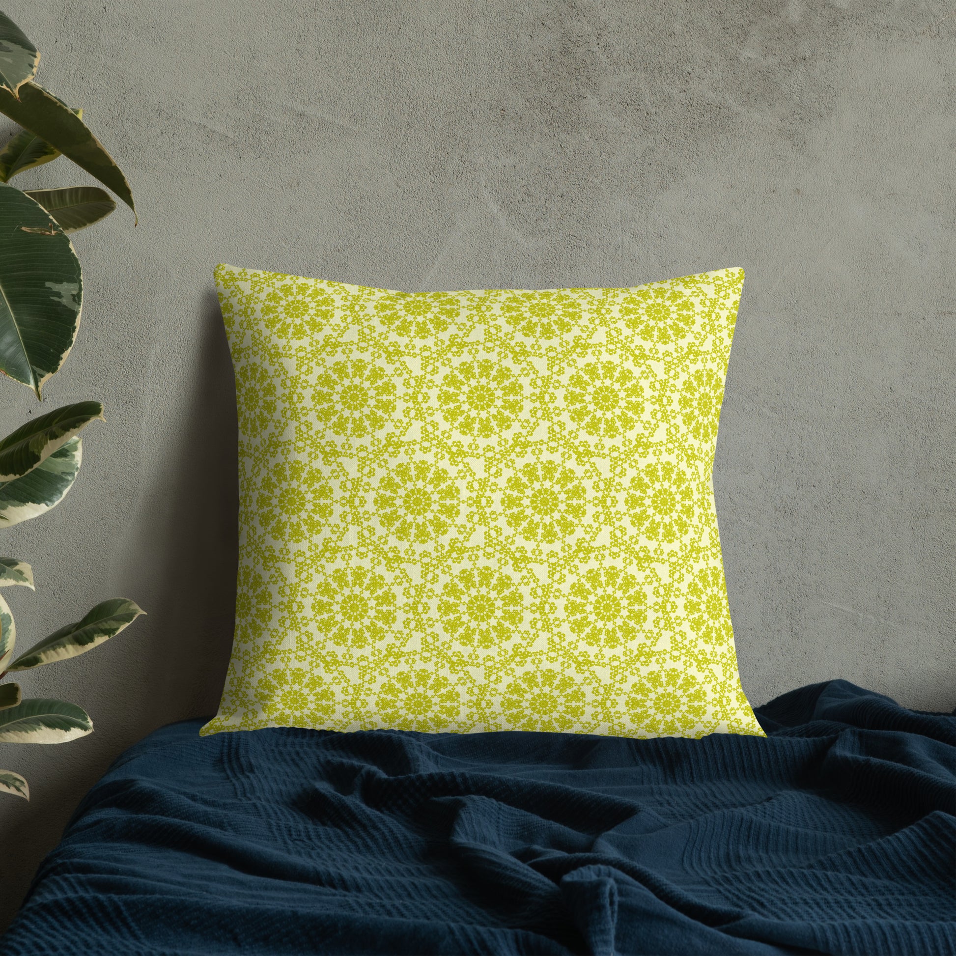 22″×22″ premium throw pillow with the 'Hendecagon' yellow-green geometric pattern on a bed with concrete wall
