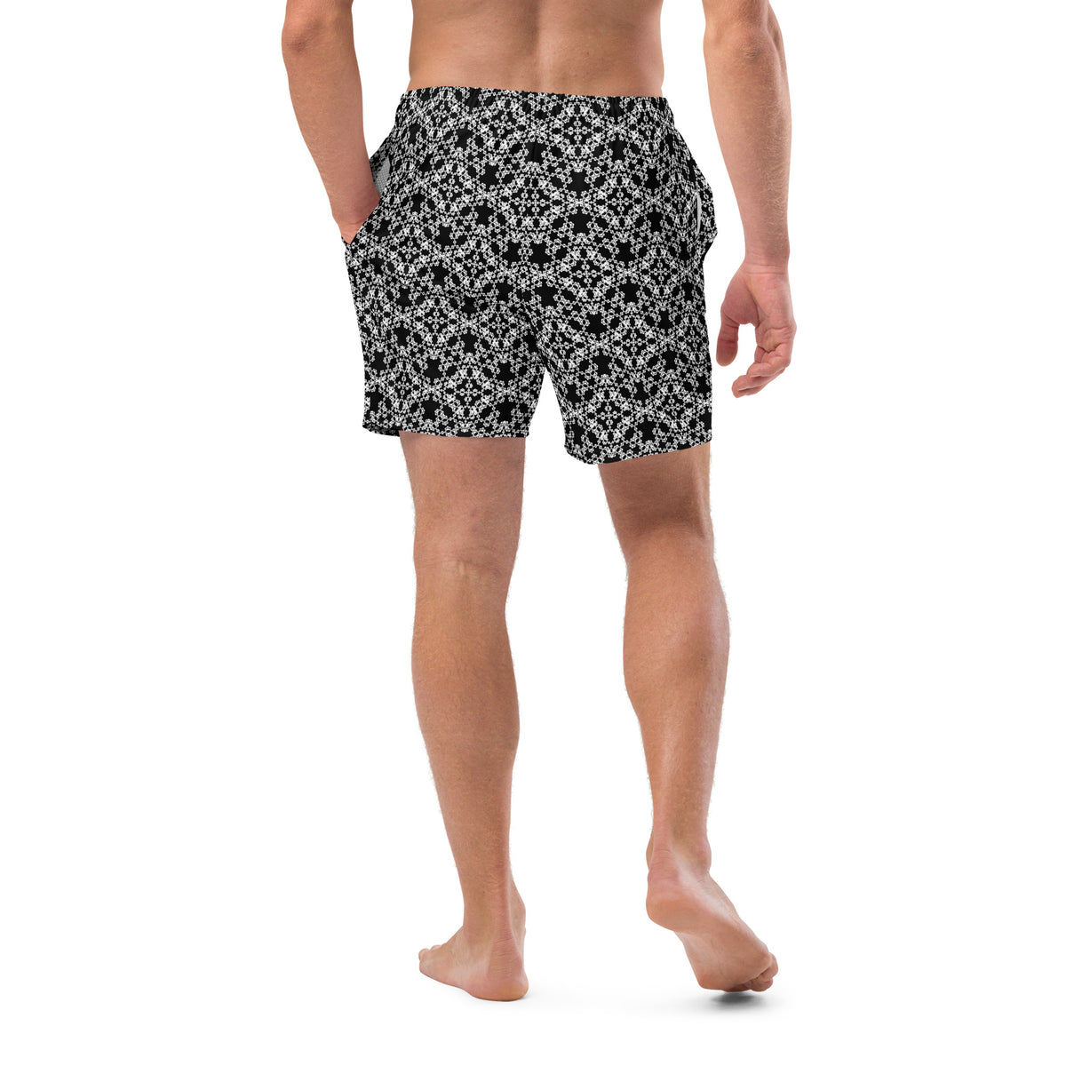 Back shot of a model wearing the swim trunks with the 'Tetragon' black and white fractal geometric pattern.