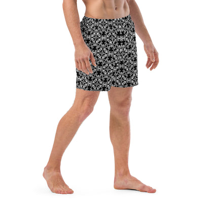 Right angle shot of a model wearing the swim trunks with the 'Tetragon' black and white fractal geometric pattern.