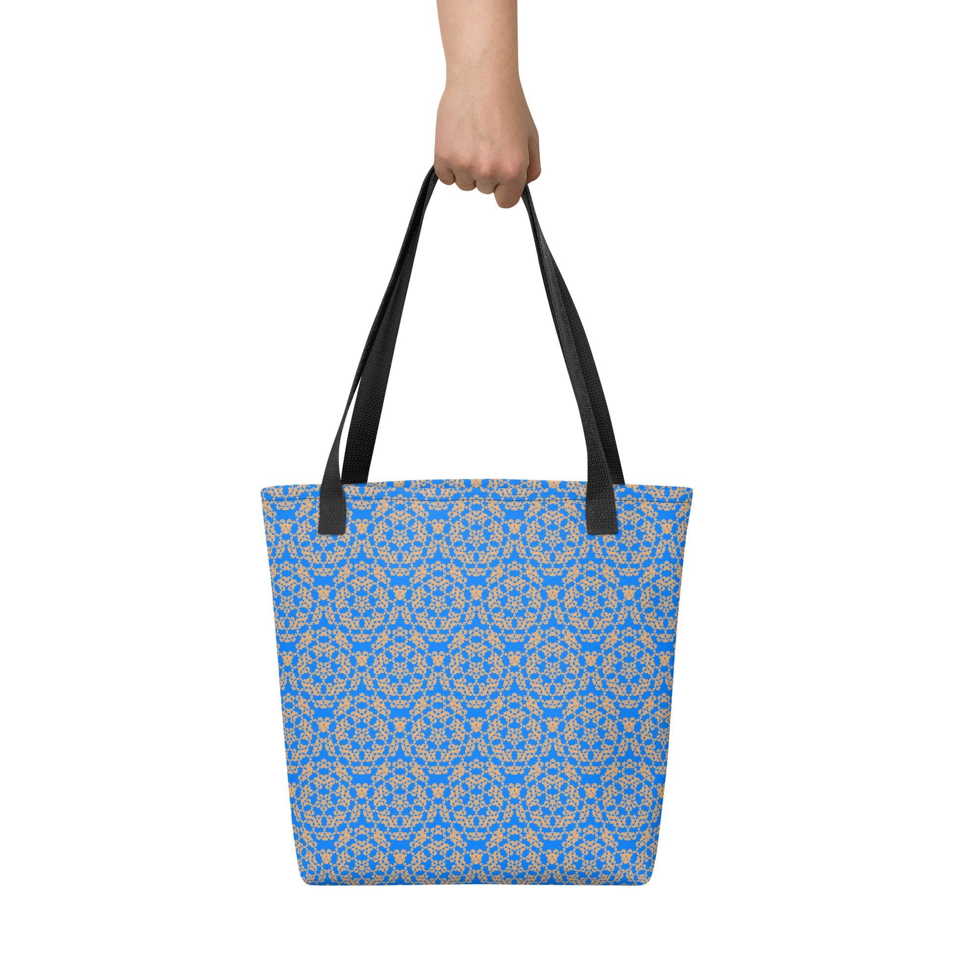 Hand holding the tote bag with the 'Pentagon' blue and yellow fractal geometric pattern.
