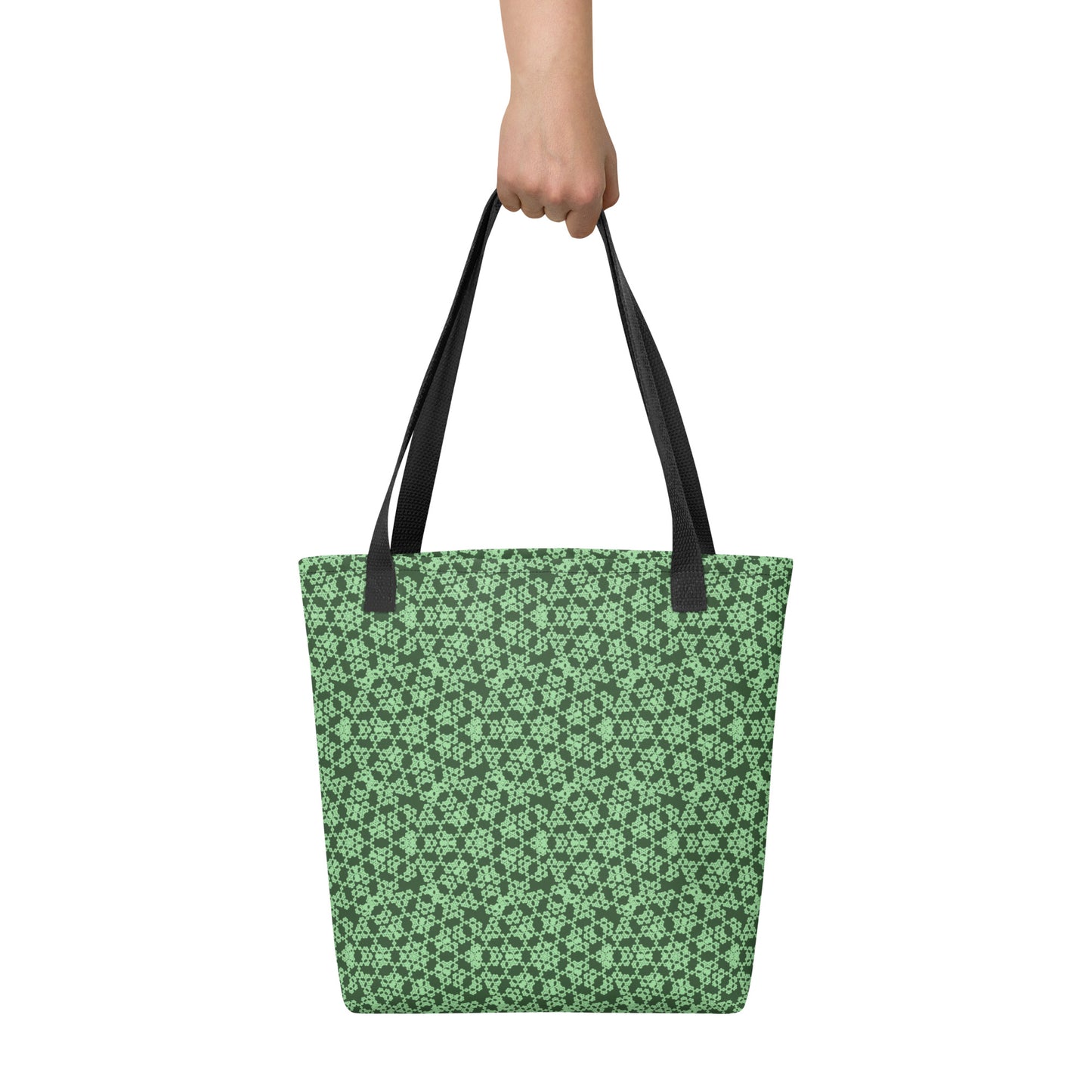 Hand holding the tote bag with the 'Heptagon' green fractal geometric pattern.