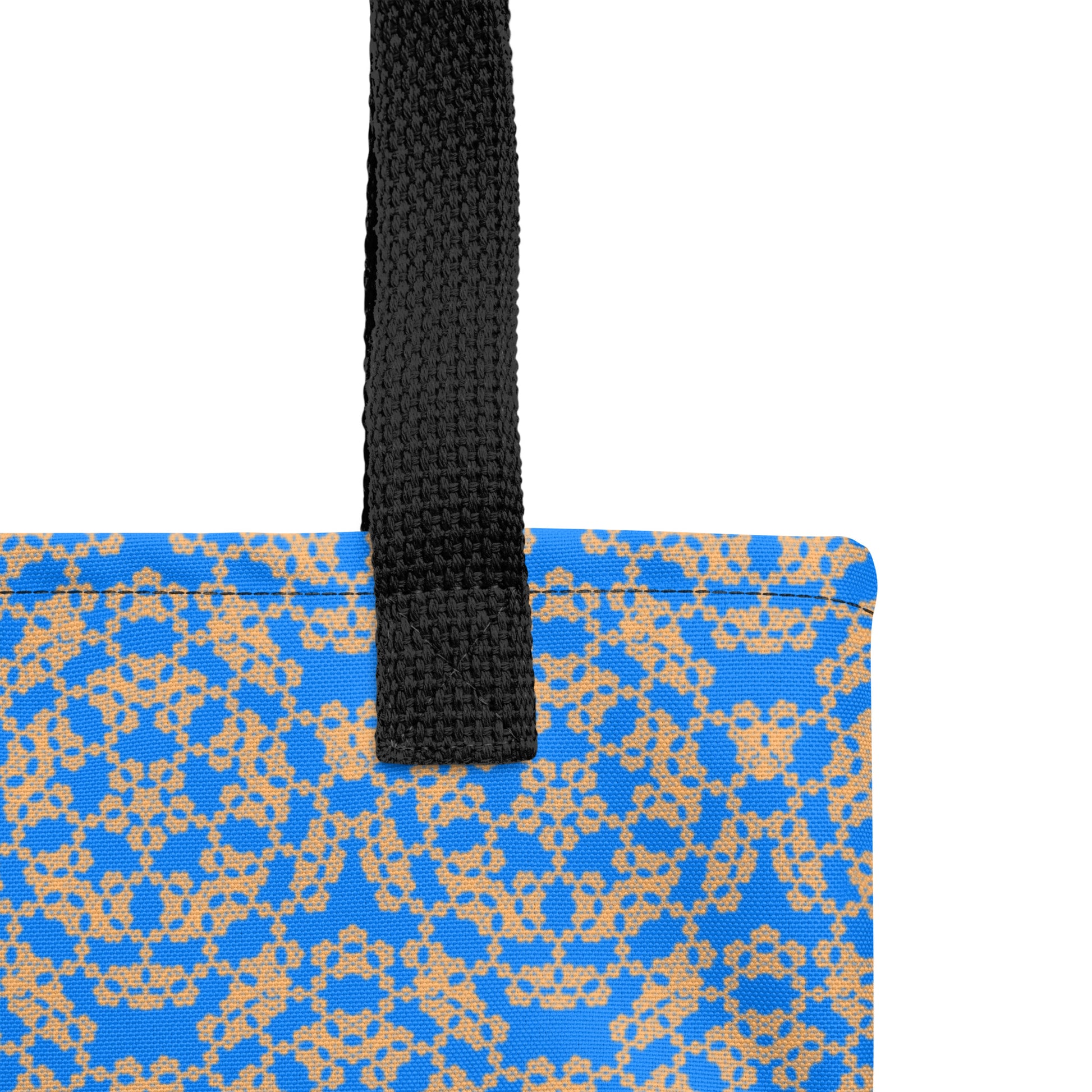Close up of the strap stitching of the tote bag with the 'Pentagon' blue and yellow fractal geometric pattern.