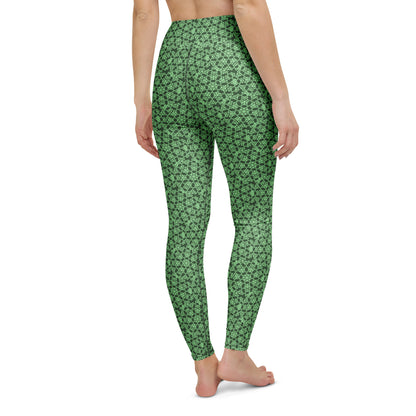 Back close-up of the legs of a model wearing leggings with the 'Heptagon' green fractal geometric pattern.