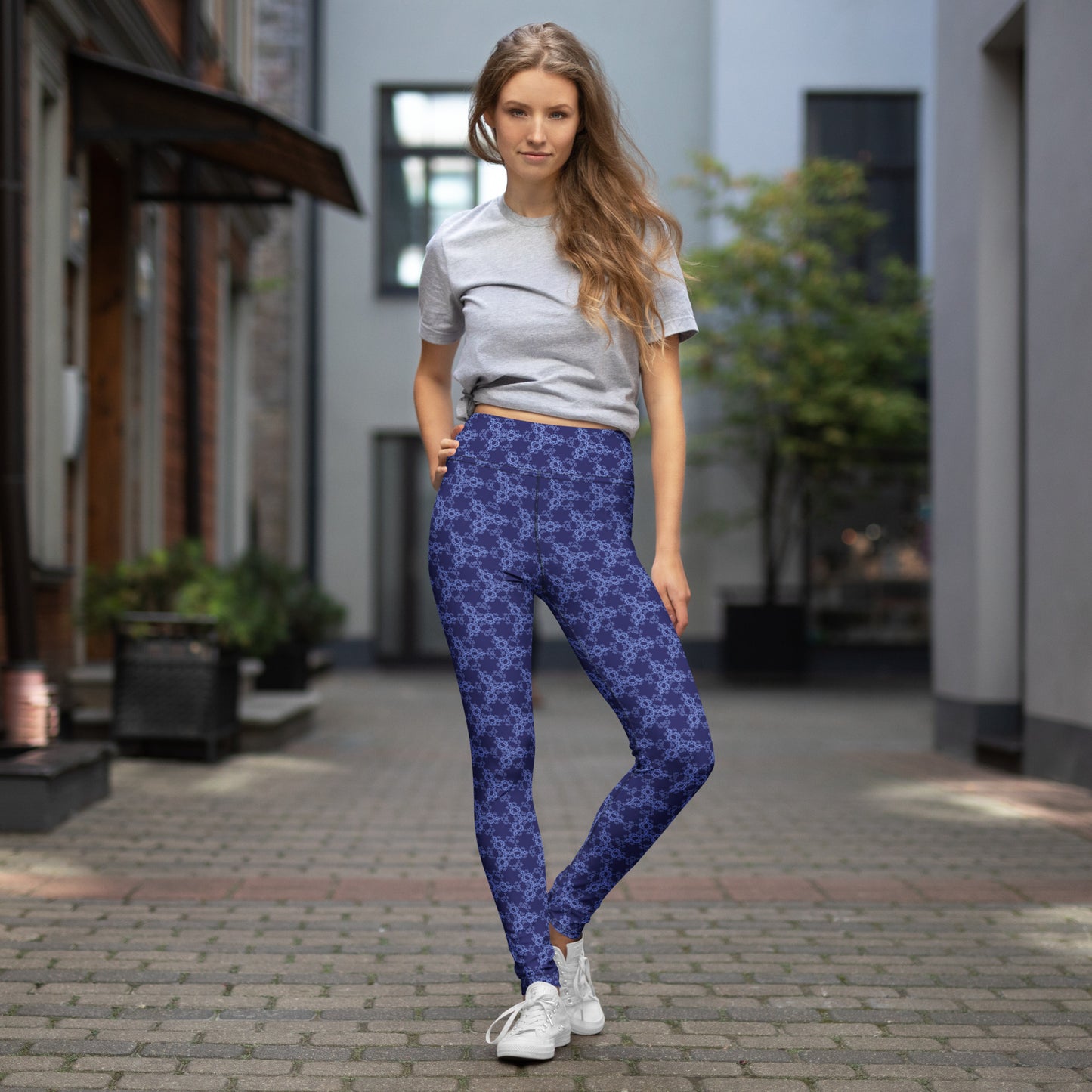 Young woman wearing leggings with the 'Triagon' navy and blue fractal geometric pattern.