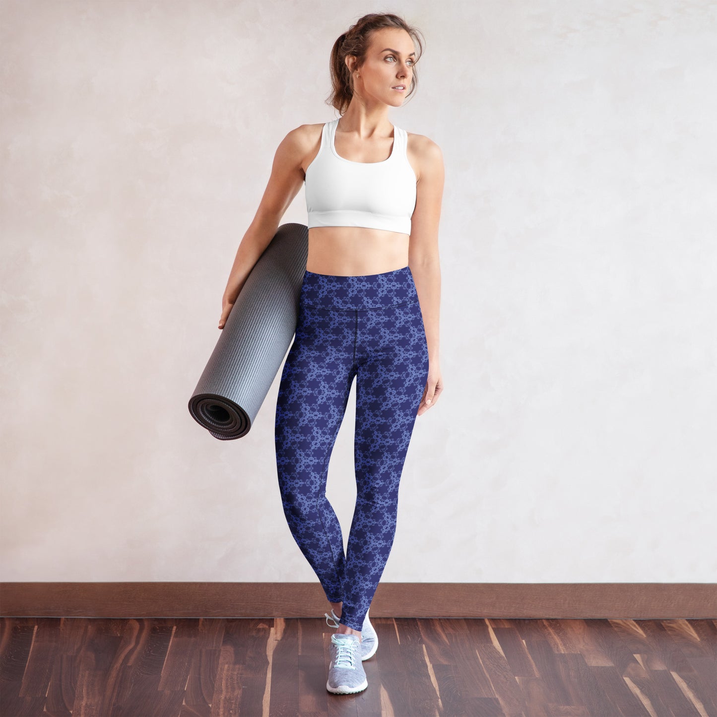 Young woman wearing leggings with the 'Triagon' navy and blue fractal geometric pattern.
