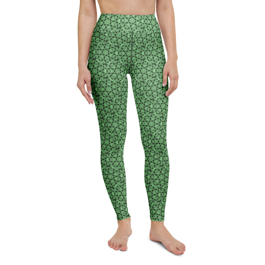 Front close-up of the legs of a model wearing leggings with the 'Heptagon' green fractal geometric pattern.