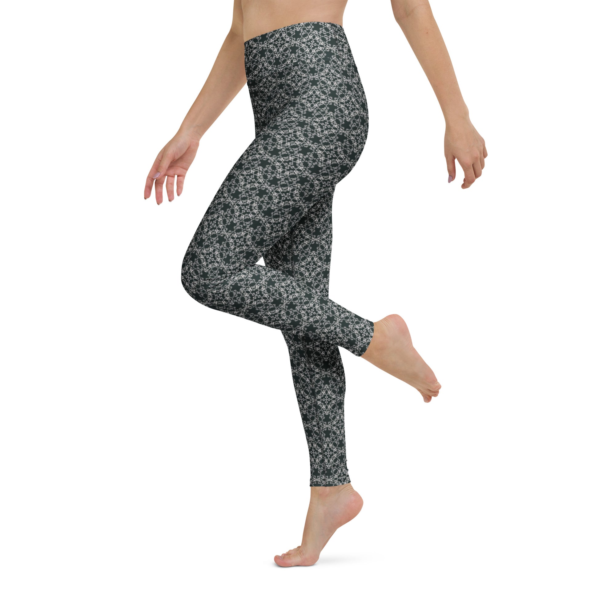 Left close-up of the legs of a model wearing leggings with the 'Quadragon' charcoal and white fractal geometric pattern.