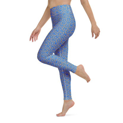 Left close-up of the legs of a model wearing leggings with the 'Pentagon' blue and yellow fractal geometric pattern.