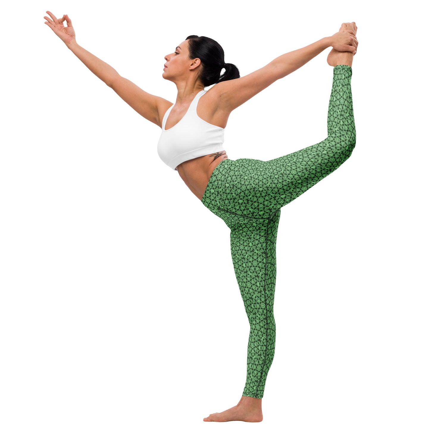 Young woman in a yoga pose wearing leggings with the 'Heptagon' green fractal geometric pattern.