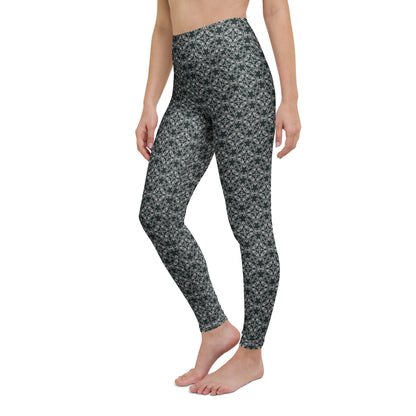 Left-front close-up of the legs of a model wearing leggings with the 'Quadragon' charcoal and white fractal geometric pattern.