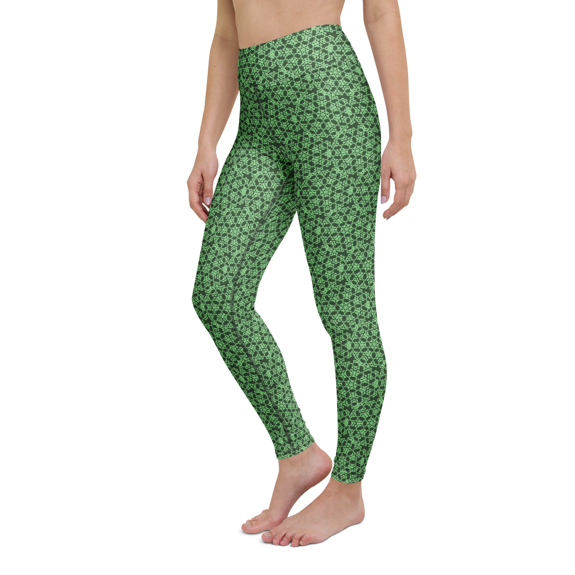 Left-front close-up of the legs of a model wearing leggings with the 'Heptagon' green fractal geometric pattern.