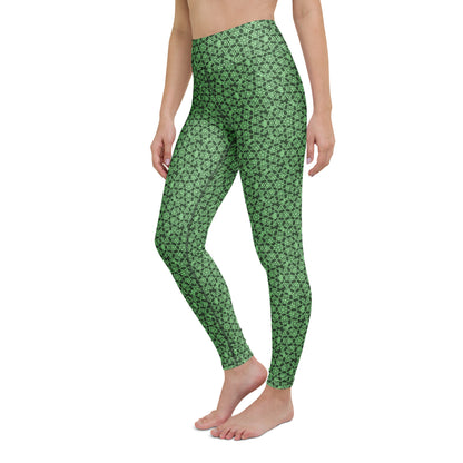 Left-front close-up of the legs of a model wearing leggings with the 'Heptagon' green fractal geometric pattern.