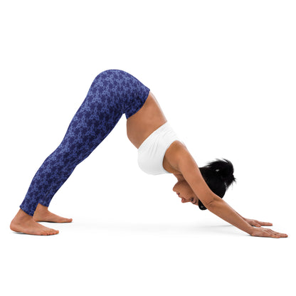 Young woman in a yoga pose wearing leggings with the 'Triagon' navy and blue fractal geometric pattern.