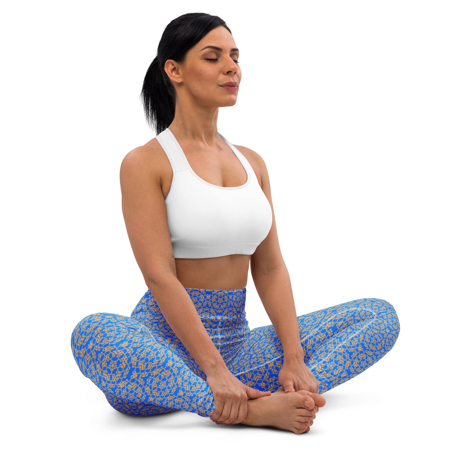 Young woman sitting in lotus position wearing leggings with the 'Pentagon' blue and yellow fractal geometric pattern.