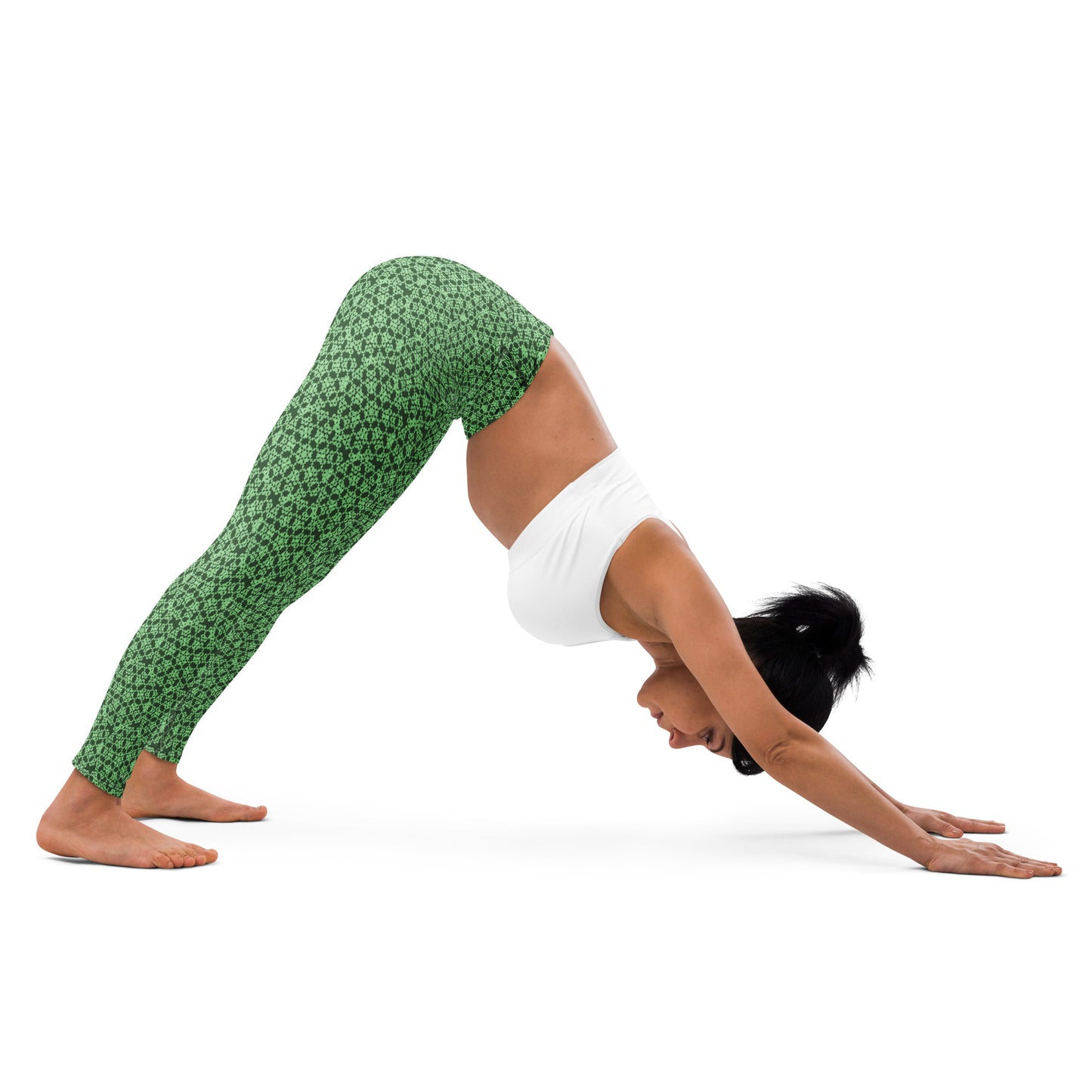 Young woman in a yoga pose wearing leggings with the 'Heptagon' green fractal geometric pattern.