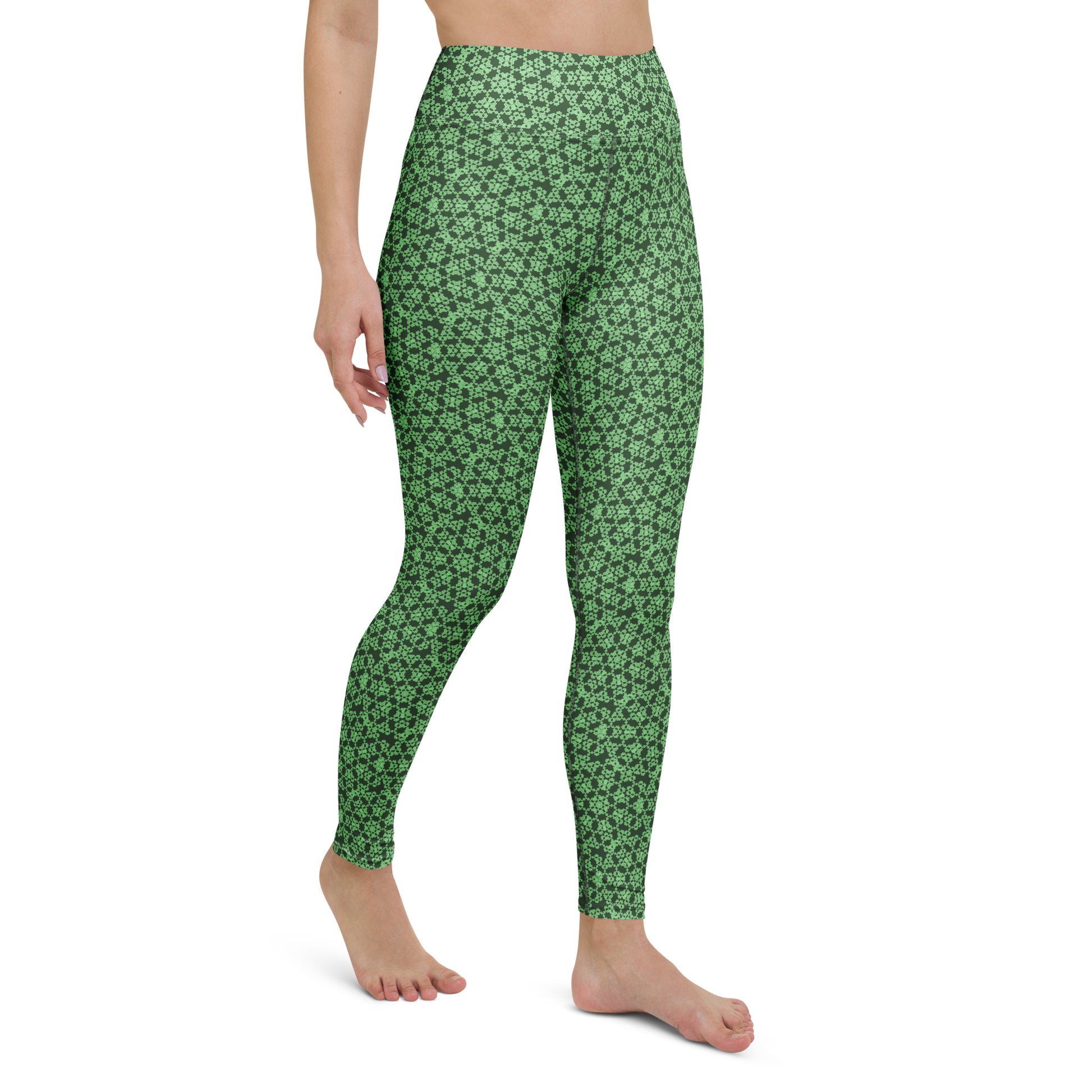 Right-front close-up of the legs of a model wearing leggings with the 'Heptagon' green fractal geometric pattern.
