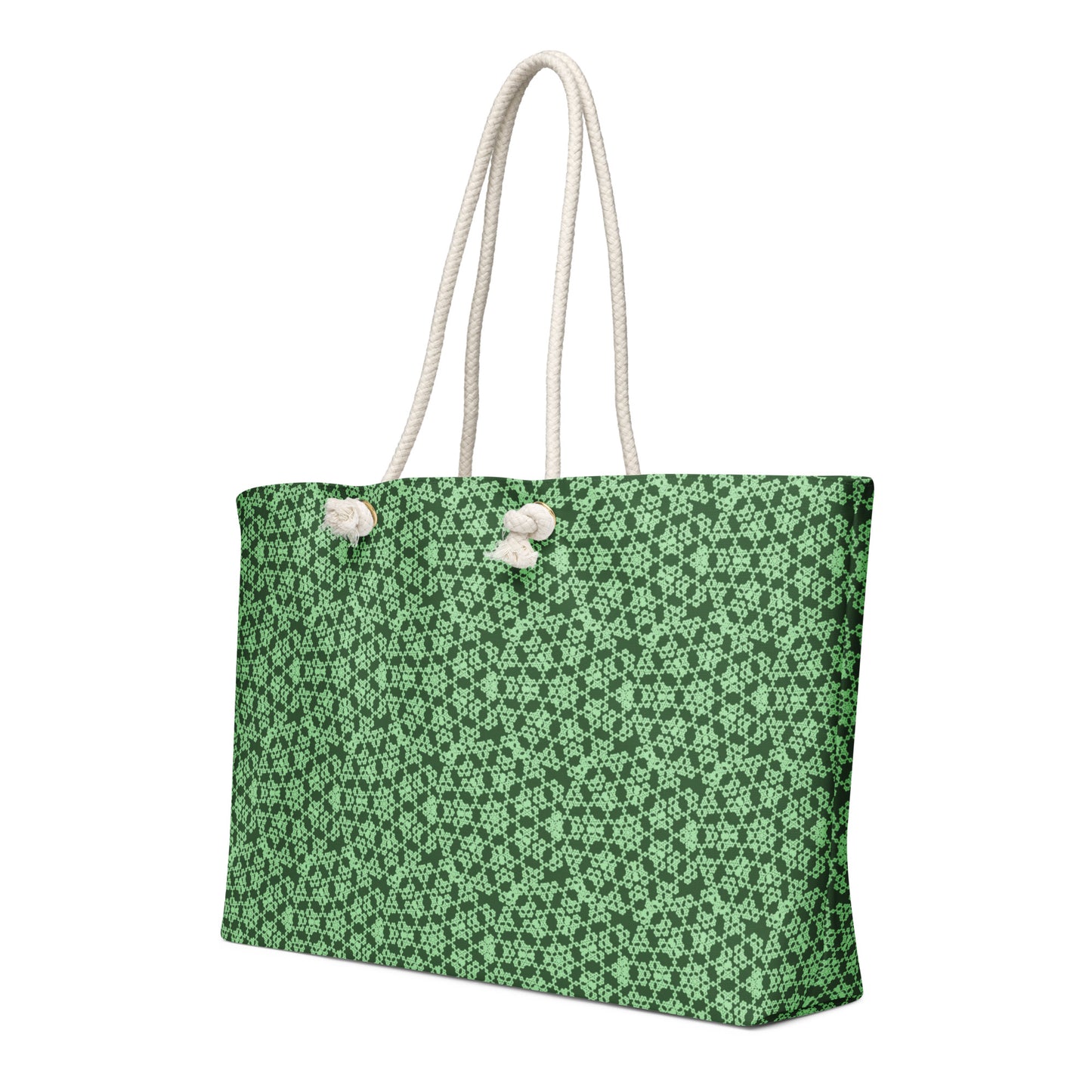 Hand holding the oversized weekender bag with the 'Heptagon' green fractal geometric pattern.